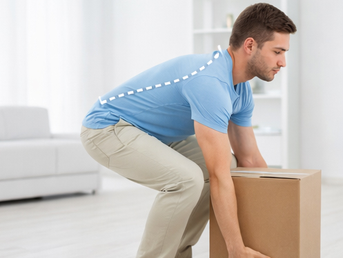 A man using safe lifting techniques to lift a cardboard box