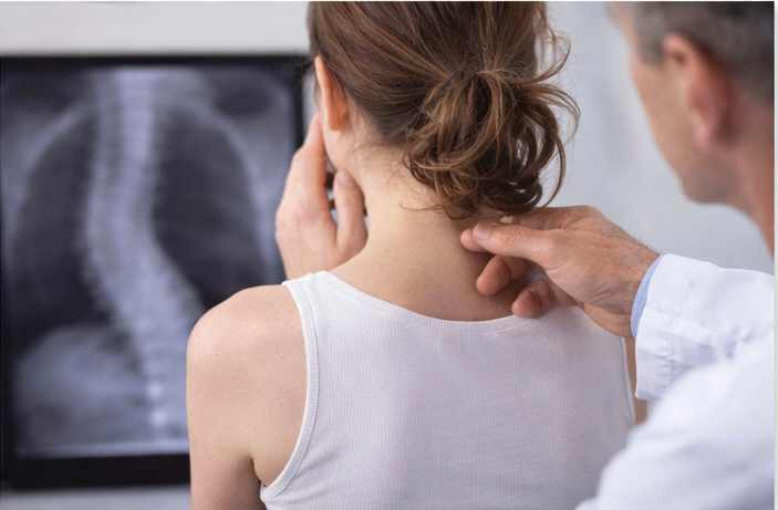 A chiropractor assessing cervical spine mobility and alignment in a patient experiencing vertigo and dizziness